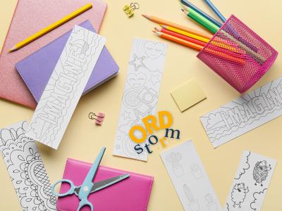 Bogmærker, blyanter og sakse på et bord.